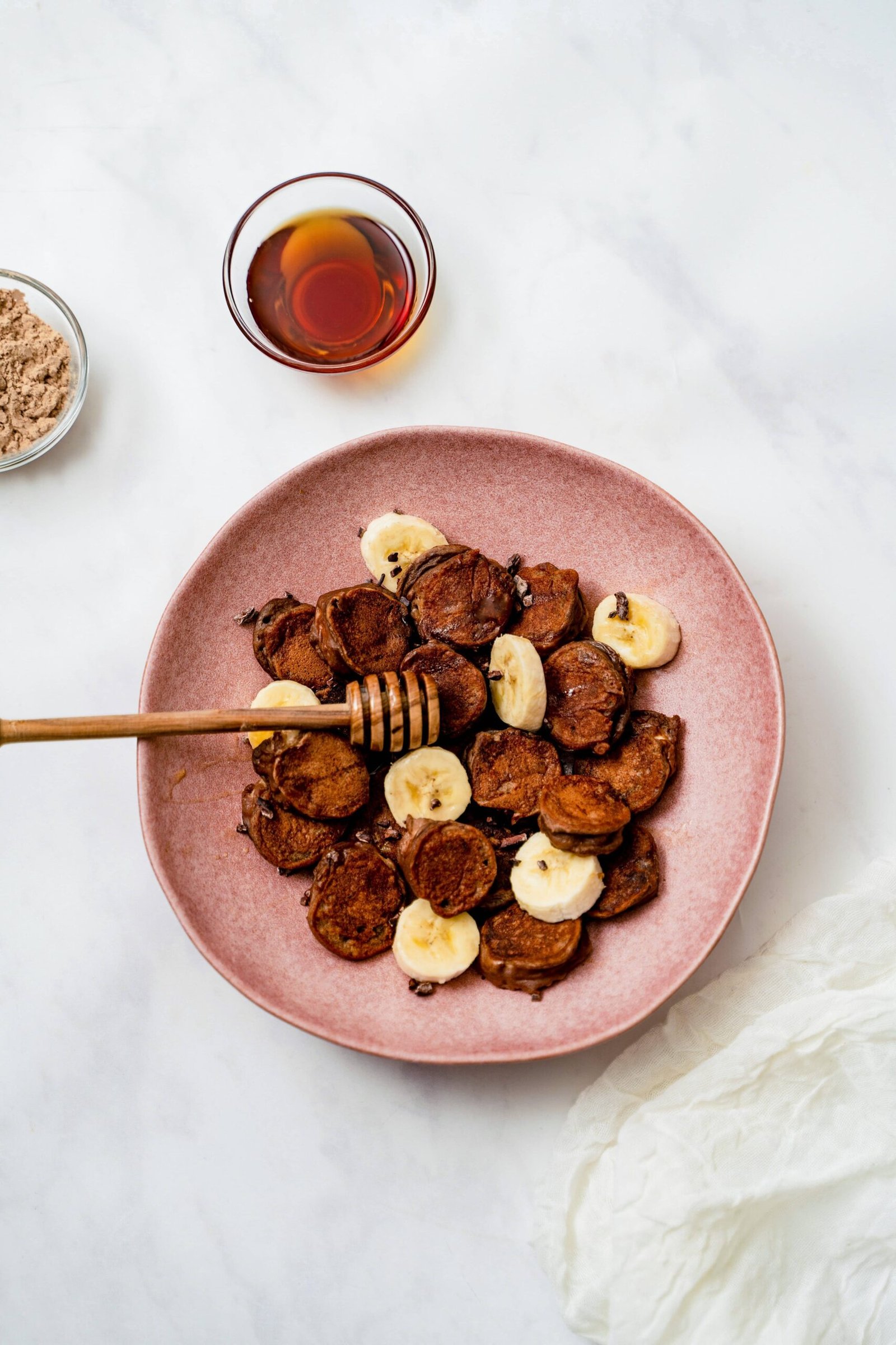 Plat rempli de rondelles de bananes enveloppées de pâte à pancake protéinée au chocolat