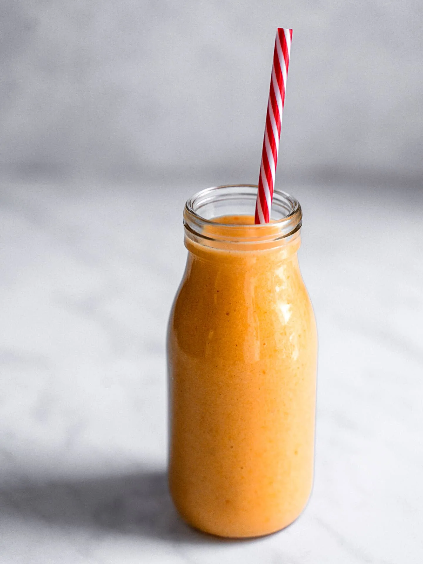 Verre de smoothie orange avec une jolie paille