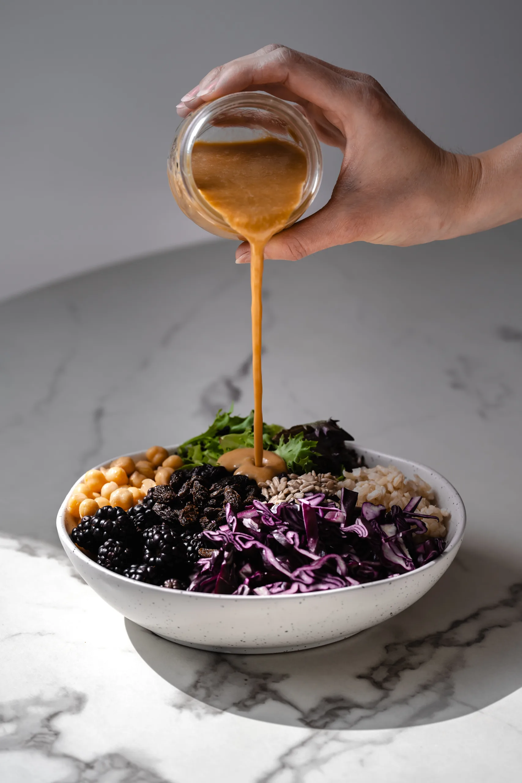 Sauce au beurre de tournesol versé sur un bol Bouddha